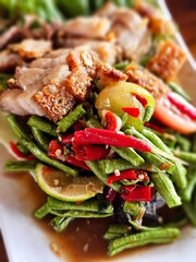 Long bean salad with crispy pork has a spicy taste.
