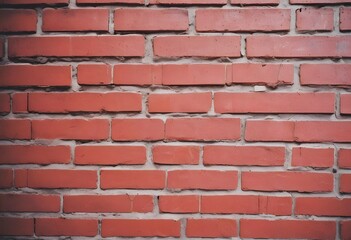 Obraz premium Close-up of a weathered red brick wall background with visible mortar joints and a textured surface