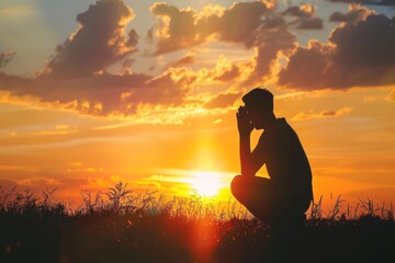 Christian prayer. Man on his knees praying on sunset background. Kneeling prayer to God. Worship and praise