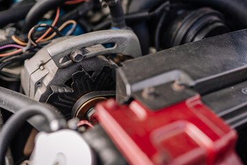 limbazi, Latvia, June 29, 2024 - Close-up of a car engine component with visible wiring and pulleys, highlighting mechanical details and complexity. Some copy space.