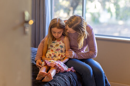 mother comforting her child in bedroom seen through open door