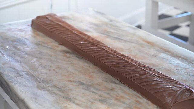 Mackinac Island chocolate fudge ready for cutting on a large marble confectionary table