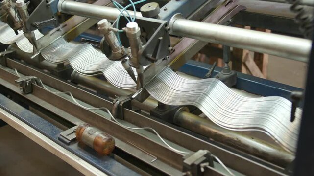 High-resolution 4K clip showcases close-up of metal wire being fed through a factory production line after automatic cutting. Ideal for industrial and manufacturing videos.