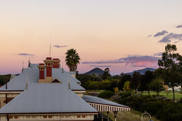 Rooftop of the historic Mudgee Railway Station with pink and purple twilight sky