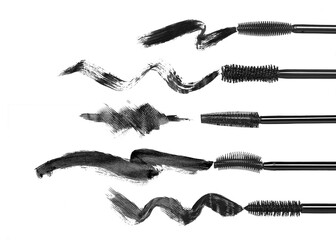 Set of various mascara brushes with mascara strokes on white background