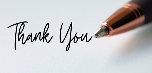 Thank you text on white background with close up of pen.