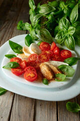 Mozzarella with basil and cherry tomatoes sprinkled with Mediterranean spices.