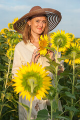 Happy girl in a field of sunflowers, summer mood of joy.