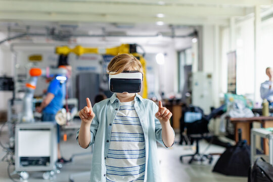 Portrait of schoolboy with VR headset on head. Children learning robotics in Elementary school, using modern technology, virtual reality.