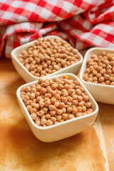 Three bowls of chickpeas with red checkered cloth.
