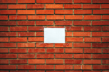 Blank white notice paper mockup on the brick wall