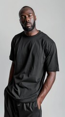 Obraz premium A black male model wears all-black outfit in studio pose