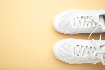 White sneakers on a beige background. Space for text