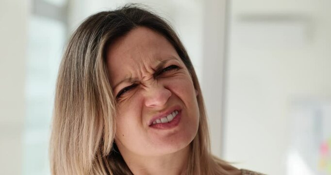Squinting woman with poor eyesight tries to see small items