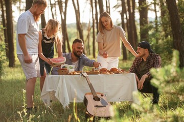 Obraz premium Positive mood, having fun. Group of friends are having picnic on the field with food in eco boxes