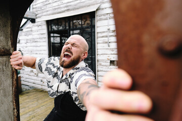 Man taking effort to pull doorway of old building