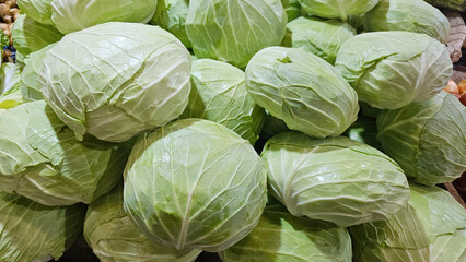 Obraz premium Fresh green cabbage on the market stall selling vegetables