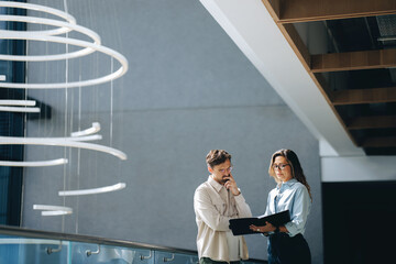 Business people read and discuss the terms of their agreement in an office setting