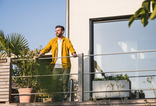 Happy man standing on terrace