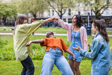 Carefree female friends dancing at park