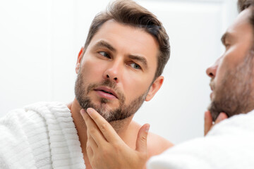 Fototapeta premium Male beauty. Cream treatment for male face. Beauty routine. Face of a beautiful man with perfect skin. Anti-aging and wrinkle cream. Concept of male beauty. Male skincare cosmetics concept. Skin care.