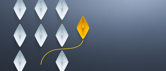 Group of white paper ships in one direction and one yellow paper ship pointing in different way....
