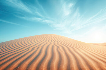 Naklejka premium The image shows a vast expanse of sand dunes under a clear blue sky