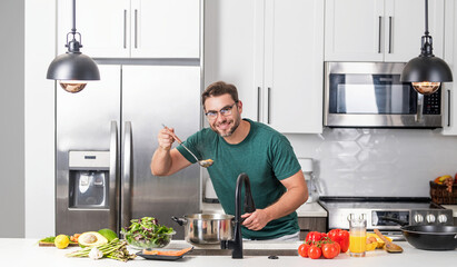 Man cook cooking at kitchen. Chef cook man prepares a dish with food in saucepan. Menu recipe healthy food. Man cook food in modern kitchen. Mature man standing in kitchen, preparing food.