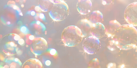 Soap bubbles with rainbow reflections on beige background. Abstract background. Cleaning concept, banner for eco-friendly article or for cleaning service.