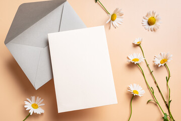 Empty blank card,  envelope and chamomile flowers