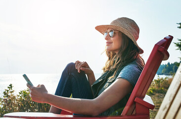 Nature, relax and woman with mobile for holiday, summer vacation or happiness. Outdoor, sunglasses and female person sitting in chair for weekend trip, comfortable or peaceful morning in Michigan