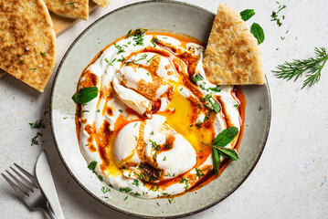 Turkish eggs Cilbir and fresh pita bread