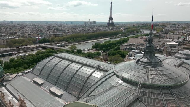 Glass roof and dome of Grand Palais or Great Palace with Tour Eiffel tower in background, Paris cityscape, France. Aerial drone panoramic view