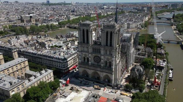 Work reconstruction progress at Notre Dame de Paris, France. Aerial backward ascending and cityscape