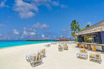 Outdoors beach bar with clear blue sea sky. Relaxing beachfront bar with chairs sun umbrellas. Luxury summer travel background. Freedom tropical sunny coast, summertime vibes pattern. Exotic tourism