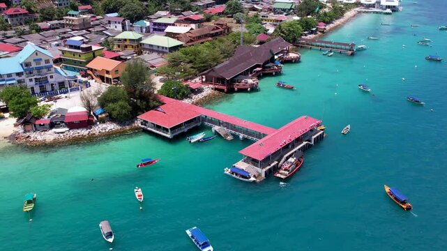 Terengganu, Malaysia - March 16, 2023 Aerial moving backward revealing the Jetty area in Pulau Perhentian. 4K