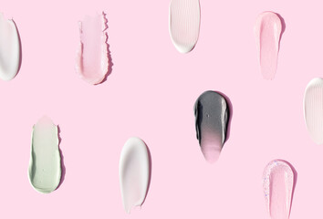 creamy texture of cosmetic samples on pink background