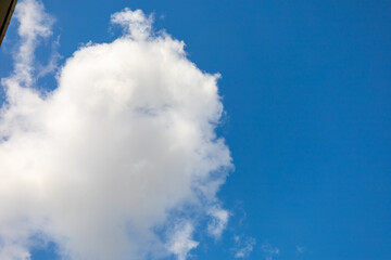 Obraz premium Fluffy White Cloud Against Clear Blue Sky