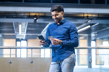 Using smartphone and holding credit card, man making online payment