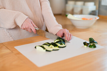 Zucchini being cut with kitchen knife