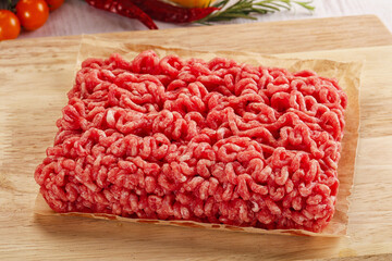 Raw minced beef meat over board