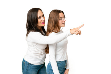 mother and daughter over isolated chroma key background presenting an idea while looking smiling towards