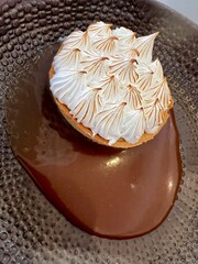 Photo of a mango and cream tartlet with chocolate syrup. Desserts and sweets