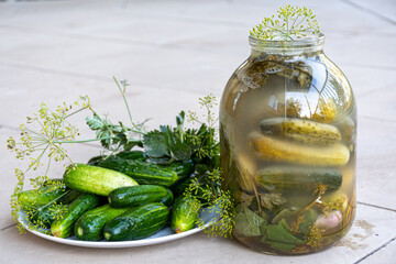 Fresh and pickled cucumbers in glass jar, preserving vegetables for the winter