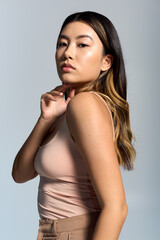 Naklejka premium A beautiful Asian woman with long hair looks directly at the camera with a confident expression.