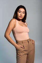 Obraz premium A woman poses confidently in stylish attire, hands in pockets.