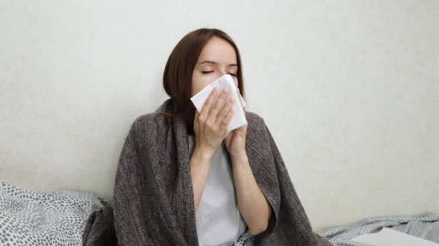 Teenage girl with runny nose, sneezing and unwell at home, person suffering from cold and flu.