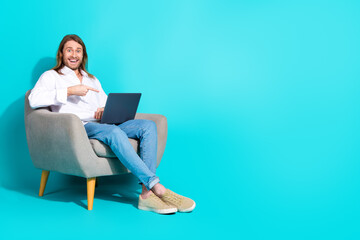 Full length photo of cheerful positive guy dressed white shirt showing finger modern device emtpy space isolated turquoise color background