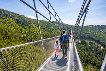 Tourists walk across the Sky Bridge 721, the worlds longest suspension footbridge, located in the...