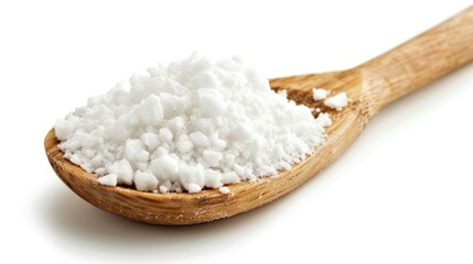 A wooden spoon filled with white sugar sitting on a plain white surface